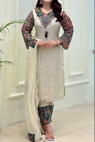 Woman wearing a traditional outfit with floral patterns in a well-lit room.