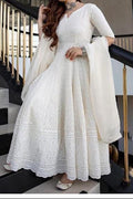 Woman in a white traditional outfit standing on a staircase