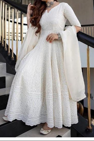 Woman in a white traditional outfit standing on a staircase
