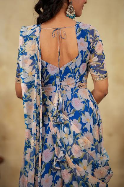Woman wearing a blue floral dress with a plain background